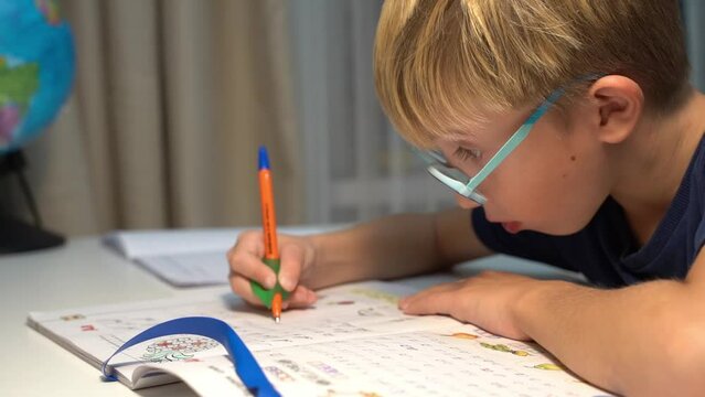 a first-grader boy does his homework