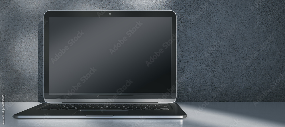 Aufkleber Wide image laptop computer with empty mock up screen placed on desk. Concrete wall with shadows in the background. 3D Rendering.