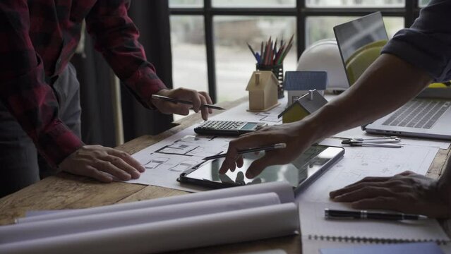 civil engineer team With architect and foreman meeting to view blueprints and construction plans in the office. 4K Video