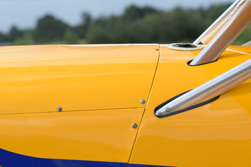 Side of a light aircraft. yellow. Close-up, rivets, texture, surface