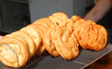 pancakes fried in boiling oil for sale in the street food stall during the village festival