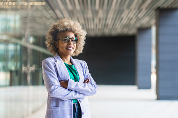 Young inspired African American business woman with arms crossed looking to the camera. Successful...