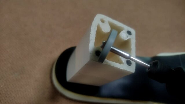 Shoe maker repairs heel on women's shoes