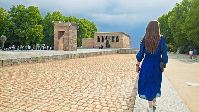 A Tourist woman visiting the Temple of Debod Monument in Madrid Spain, Europe. A female walks by the Ancient Egyptian temple and museum from Aswan