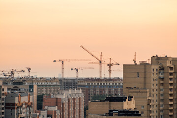 Cranes and building with evening sky background