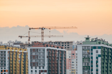 Fototapeta na wymiar Cranes and building with evening sky background
