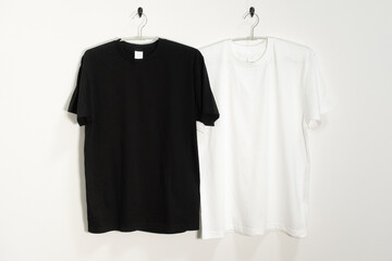 ハンガーにかけられた白と黒のTシャツ