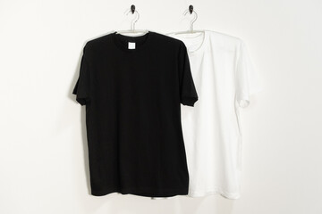 ハンガーにかけられた白と黒のTシャツ