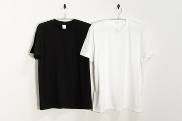 ハンガーにかけられた白と黒のTシャツ