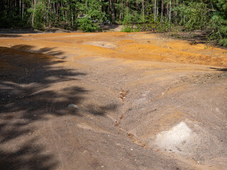 Dry stream bed with ferric mud of sediments on big boulders - 642882894