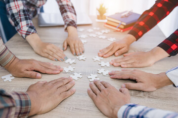 Group of business people putting their hands on a table with jigsaw puzzles. concept of cooperation teamwork Help and support in business Symbols of associations and connections business strategy.