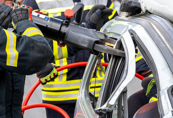 Feuerwehr im Einsatz, um in einem Auto eingeklemmte Person zu bergen. Durchtrennen der B-Säule und des Türholm mit Hydraulische Rettungsschere