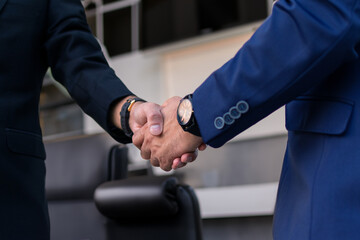 Two diverse professional business men executive leaders shaking hands at office meeting
