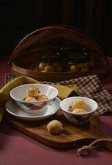 handmade mini bake luxury peranakan nonya pineapple paste tart cookies w clove stick in asian traditional rooster bowl wood plate on maroon background pastry dessert halal festive food cake shop menu