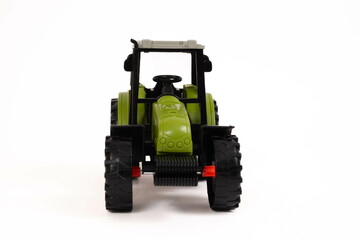 A green, orange and grey toy  farm tractor   isolated on a white background