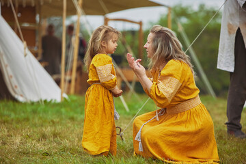 Beautiful woman with her daughter dressed in embroidered dresses