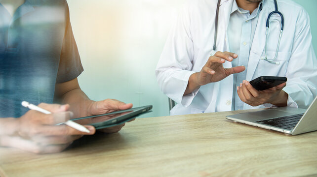 Smart medicine doctors working with computer notebook and digital tablet  at desk in the hospital. Medical concept.Medical teamwork discussion