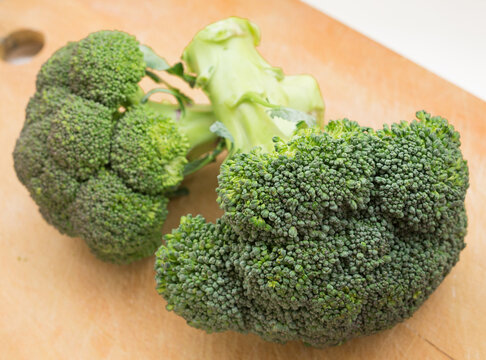 Healthy broccoli and florets on wooden board