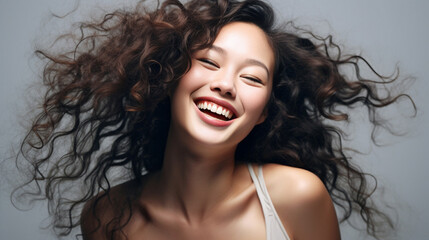 Fototapeta premium Headshot of girl with curly hairstyle wearing grey camisole send sweet on grey color background. Red brown curly hairstyle concept. Generative AI.