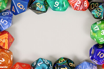 Colorful role playing RPG dice forming border around gray background with copy space