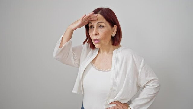 Middle age woman looking for faraway celebrating over isolated white background