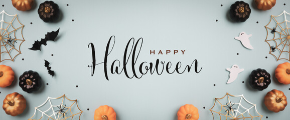 Halloween holiday background with party decorations from  pumpkins, bats, ghosts, spider webs on blue top view. Greeting card with text inscription Happy Halloween in banner format.. - 642985806
