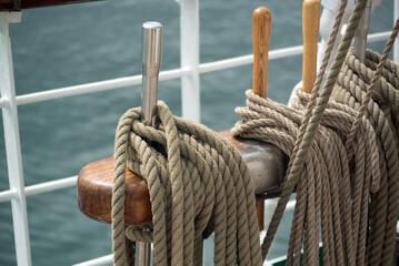 Ship ropes are laid on the rigging of a sailboat against the backdrop of sea waves - 642989657