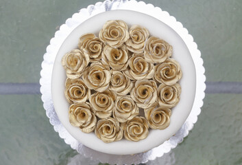 Golden fondant roses on the top of wedding cake
