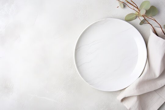 Top Down View Of White Plate Utensils And Napkin On White Stone Table Empty Space For Duplication