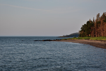St-Lawrence river Ile aux Lievres coastline. Sand beach and forest line.