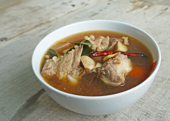 Tom Yum Pork with Clear Soup (Tom Yum Moo Nam Sai) has a distinctive sour and spicy taste. Food of Thailand. consists of Pork, dried chilies, tomatoes, galangal, kaffir lime leaves.

