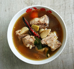 Top View of Tom Yum Pork with Clear Soup (Tom Yum Moo Nam Sai) has a distinctive sour and spicy taste. Food of Thailand. consists of Pork, dried chilies, tomatoes, galangal, kaffir lime leaves.
