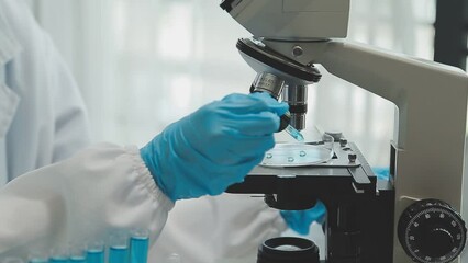 Health care researchers working in life science laboratory. Young female research scientist and senior male supervisor preparing and analyzing microscope slides in research lab. - Powered by Adobe
