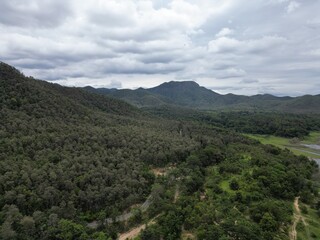 Fototapeta premium Beautiful natural scenery of a river in Southeast Asia, tropical forest with mountains in the background, aerial view, drone shot.