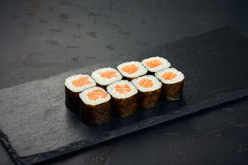 Roll with salmon on dark background. Sushi menu. Japanese food.