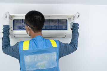 Professional male staff cleaning, air conditioning, inspection and maintenance for good hygiene and...