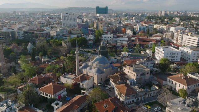 Fly over houses in historic city centre. Tekeli Mehmet Pasa Mosque and ancient sights at golden hour. Antalya, Turkey