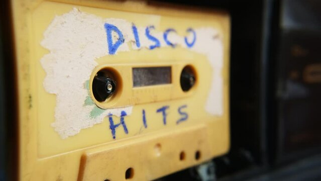 Old music audio player. Rotating tape on an old vintage cassette with inscription. Retro disco music concept.