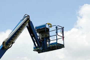 A blue crane loader high lift with cloudy and blue sky backgrounds