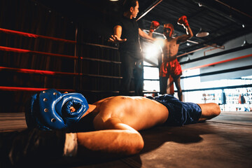Boxing referee intervene, halting the fight to check fallen competitor after knock out. Referee...
