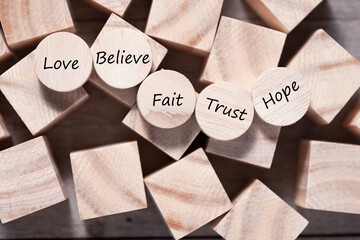 Wooden cube with inspirational text Faith, trust, believe, hope and love. Beautiful wooden table background. Business and Faith concept. Copy space - Powered by Adobe