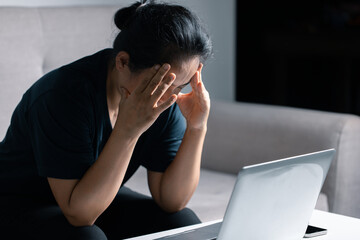 Feeling tired and stressed young woman of working age is working in the living room of the house