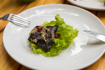 Eggplant roulade stuffed with walnuts and pomegranate fruit. Georgian appetizer.
