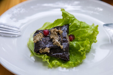Eggplant roulade stuffed with walnuts and pomegranate fruit. Georgian appetizer.