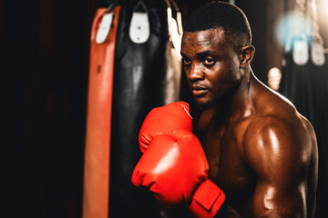 Boxing fighter shirtless posing, African American Black boxer wearing red glove in defensive guard...
