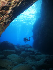 cave diving underwater scuba divers exploring caves and having fun ocean scenery sun beams and rays background