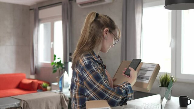 one woman checking box of received package or product at home