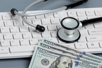 Stethoscope, cash money and computer keyboard. Medical records, data security, telehealth, and...