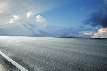 Empty asphalt road and clouds background at sunrise