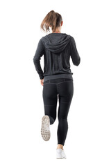 Rear backside view of female runner in hooded sweatshirt running away. Full body length portrait...